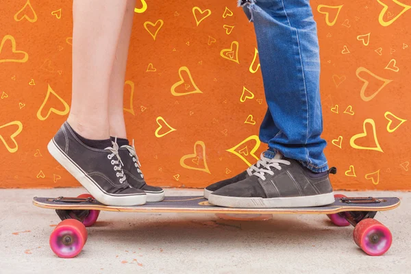 Closeup kissing couple at skateboard and red wall background — Stok fotoğraf