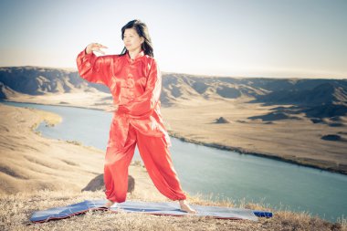Mature asian woman doing kundalini yoga clipart