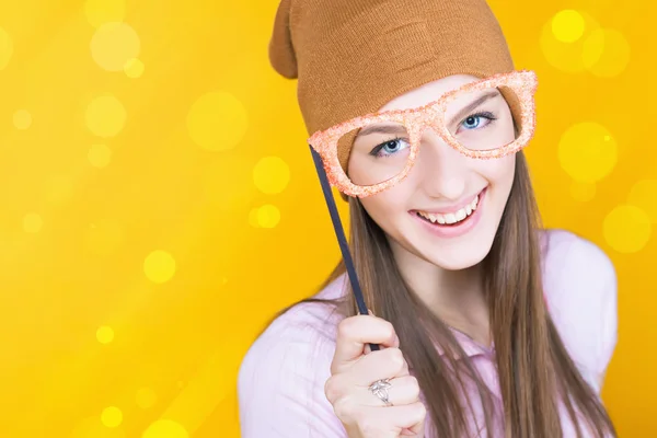 Divertida adolescente sosteniendo gafas de mascarada para fiesta — Foto de Stock