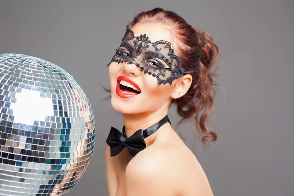 Jovem sexy mulher no carnaval máscara mantendo disco bola — Fotografia de Stock