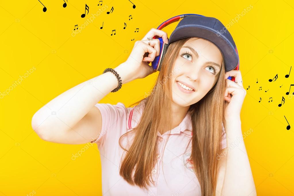Happy teenager girl uses a headphones
