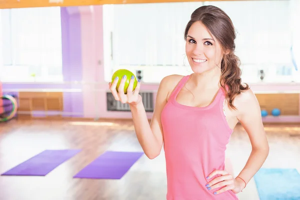 Vacker kaukasisk kvinna fitness motion håller aple — Stockfoto