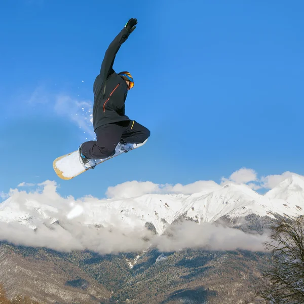 Snowboarder fazendo salto em altura acima da montanha — Fotografia de Stock