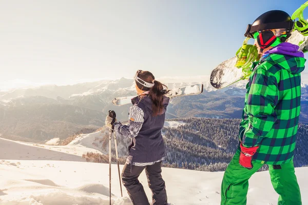 Avontuur aan wintersport. Skiër en snowboarder wandelen op de berg — Stockfoto