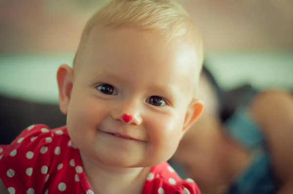 Een gelukkig lachend Kaukasische baby in het rood Stockfoto