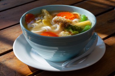 Ahşap bir masa üzerinde noodles ile sebze çorbası