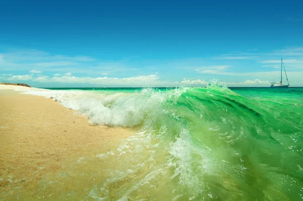 Tengeri hullámok feltörése a tengerparton, egy napsütéses napon Stock Fotó