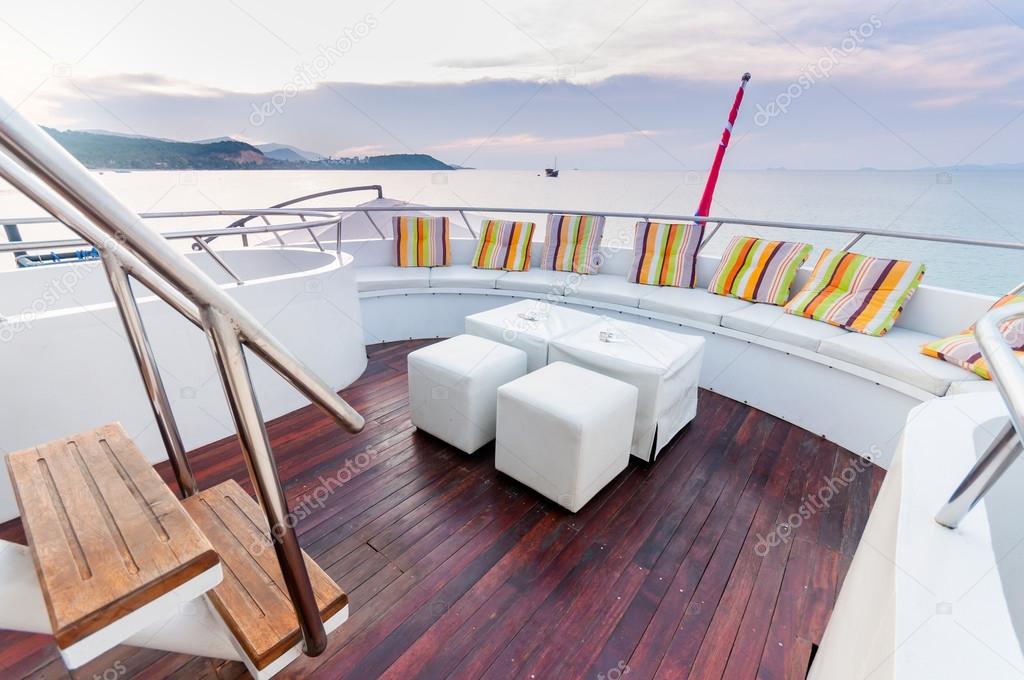 White stools and long seat on the yacht deck