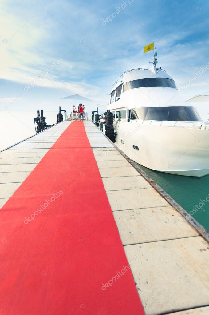 Yacht docking at the pier with red carpet to party — Stock Photo