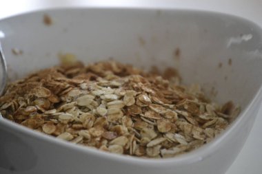 Beyaz oval bir porselen kasede tarçınlı, şekerli ve sütlü yulaf ezmesi