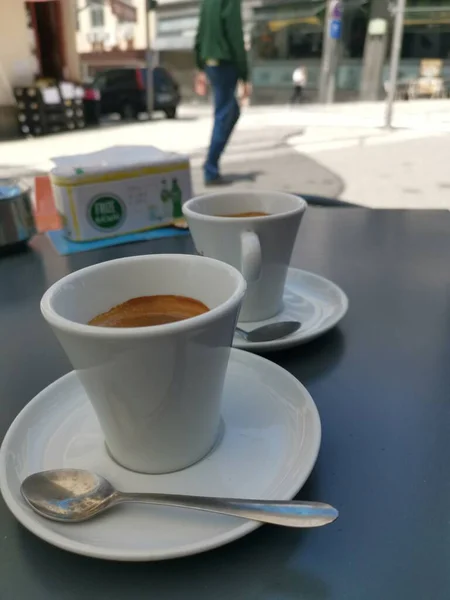 two cups of warm drink with saucer on a table