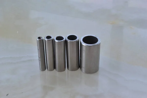 four tubes made of stainless steel in different diameters
