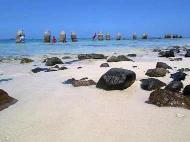 Samalona adasındaki kumsal manzarası kayalar ve taş sütunlarla dolu.