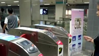 Bir kadın metroya giden kapıdan geçiyor.