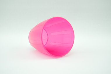 Beyaz arka plan üzerinde pembe plastik kupa
