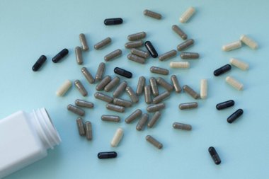 Bir sürü hap ve kapsül, açık mavi arka planda ilaçlar. Sağlıklı bir kavram. Üst görünüm.