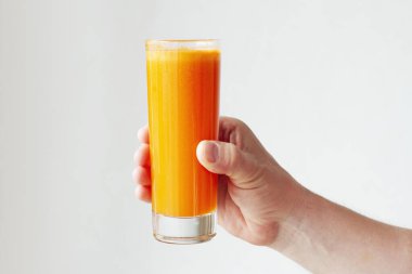 Bir bardak havuç suyu. Beyaz arka planda izole edilmiş cam üzerinde taze meyve suyu.