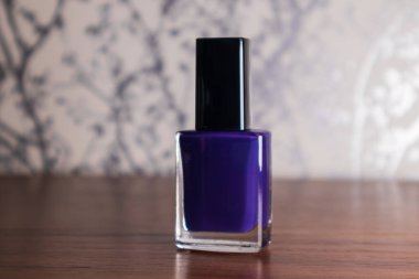 Ahşap bir masada mor oje.