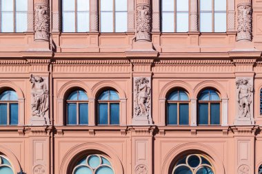 Farklı boyutlarda sütunları, heykelleri ve pencereleri olan eski bir evin arka planı