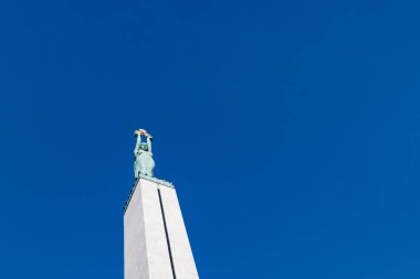 Mavi arkaplanda Letonya Özgürlük Anıtı