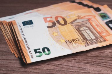 Tahta bir masada bir sürü euro banknotları var.