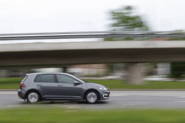 Elektrikli araba Volkswagen E Golf yolda gidiyor. Hareket bulanıklığı. Riga, Letonya - 20 Mayıs 2021.