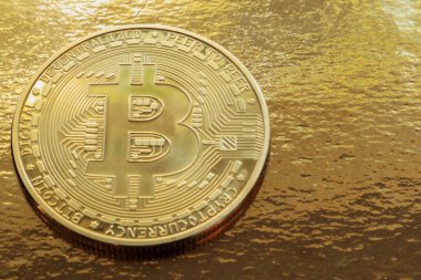 Altın yaldızlı arka planda Bitcoin para. Yumuşak odak.