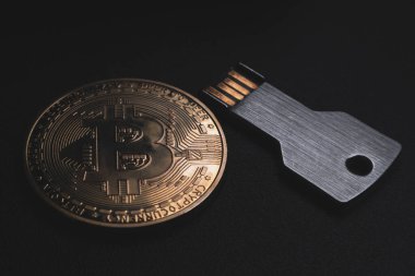 Bitcoin coin and usb flash memory on a black background. Symbolizes cryptocurrency secure storage, virtual wallet.