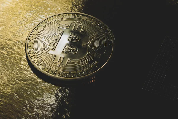 Özet ve yaldızlı arkaplanda Bitcoin madeni para.