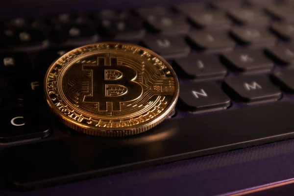 Bilgisayar klavyesinde altın bir Bitcoin 'in yakın çekimi. Yumuşak odak.