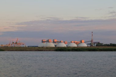 Riga, Letonya 'daki gübre terminali. Gün batımında Daugava nehrinin kıyısında büyük bir depo..