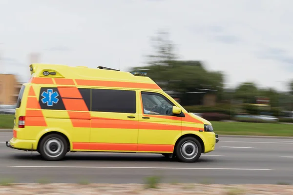 The ambulance is driving on the street at high speed. Motion blur.