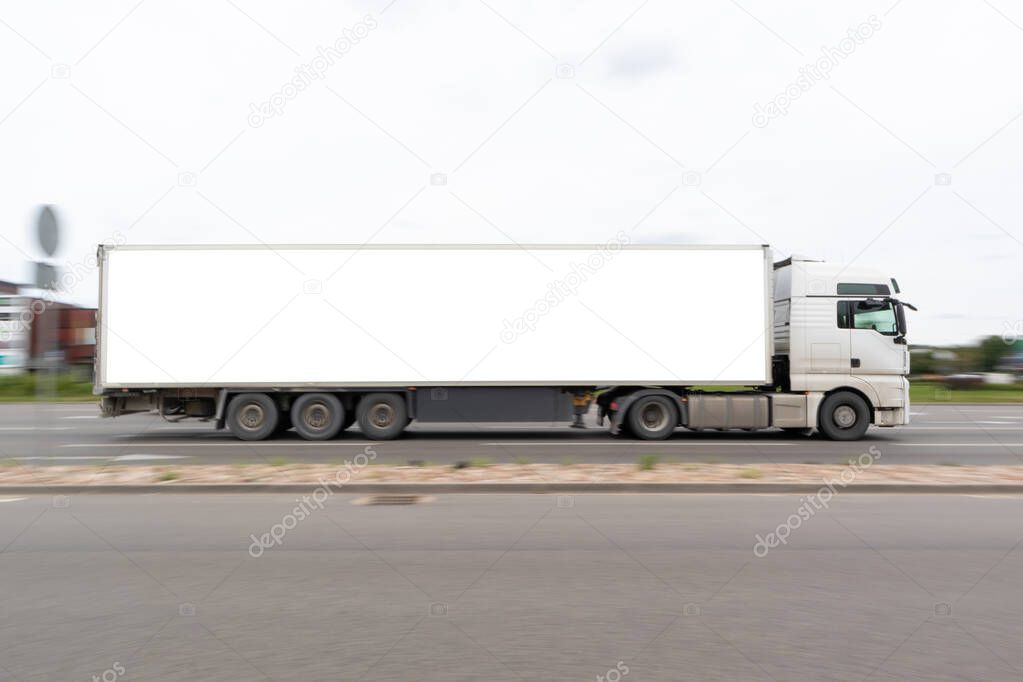 Truck with a large white semi-trailer. Free white space for text, advertising and logo on the trailer. Motion blur.