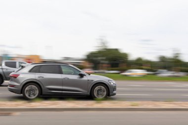Yeni Audi E-tron 55 Quattro caddede ilerliyor. Hareket bulanıklığı. Riga, Letonya - 06 Ağustos 2021..