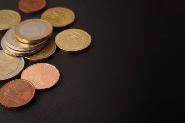 Siyah bir masanın üzerinde Euro ve euro cent paralar.