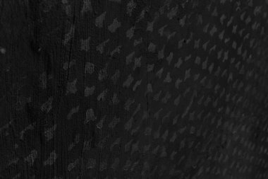 Karanlıkta eski, benekli bir duvarın eğimli manzarası. Soyut, siyah beyaz arka plan. Yumuşak odak.