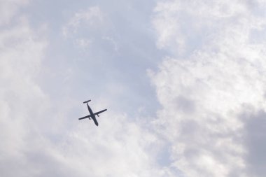 Beyaz bulutlu mavi gökyüzü ve uçan bir uçak. Yukarıdan görüntüle.