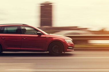 Kırmızı bir araba yüksek hızda caddede sürüyor. Hareket bulanıklığı