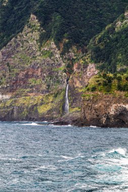 Okyanusa dökülen büyük şelaleli güzel bir uçurum manzarası..
