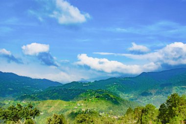 Dağları ve mavi gökyüzü olan güzel bir manzara.