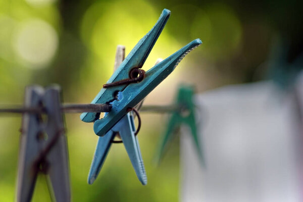 Старые веревки висят на проволоке снаружи, размытый фон, избирательный фокус. Вид сбоку.