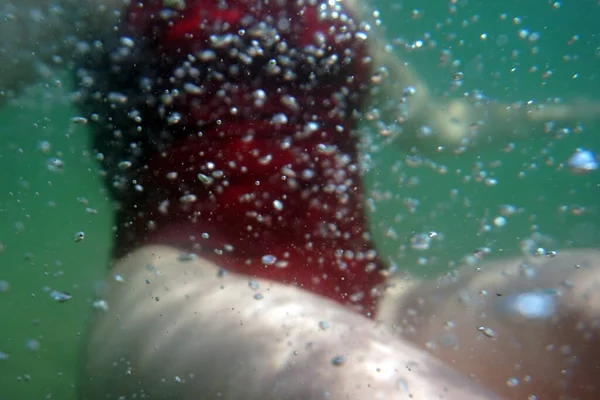赤い水着で海の中で水中で泳ぐ女性 水中で泳ぐ若い女性 — ストック写真