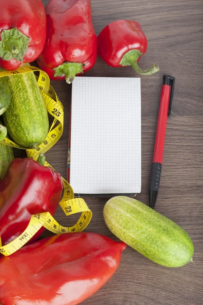 Frisches Gemüse mit Maßband auf Holzuntergrund als Symbol für gesunde Ernährung — Stockfoto