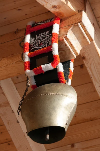Cow bell hängande under taklägga av en koja Stockbild