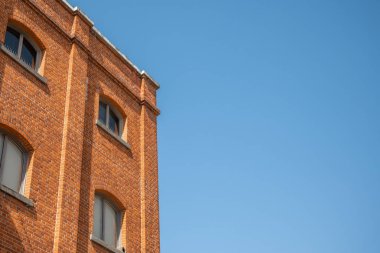 mavi gökyüzü eski kırmızı tuğla duvar pencereleri kısmen konut 