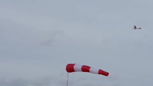 Κόκκινο μονοκινητήριο αεροπλάνο πετά πάνω από τον ανεμοθώρακα. — Αρχείο Βίντεο