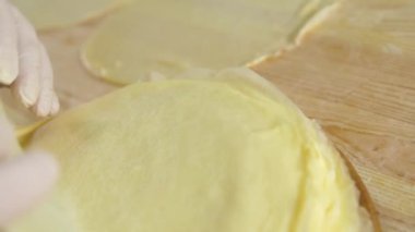 Beyaz koruyucu eldivenli eller gözlemeyi alıp masaya aktarın..