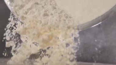 Un, ağır çekimde metal bir kaseden dökülür..