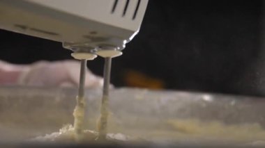 Karıştırıcı hamuru büyük metal bir kasede karıştırıyor..