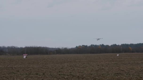 Een eenmotorig privévliegtuig landt tegen de achtergrond van een herfstlandschap. — Stockvideo